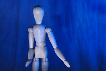 Wooden modeling doll on blue background