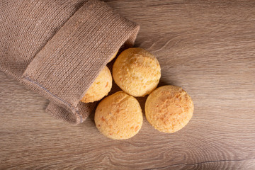 jute sachet with cheese bread on wooden background