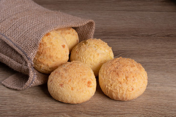 jute sachet with cheese bread on wooden background