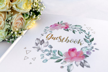 Guestbook with bouquet of flowers on a table