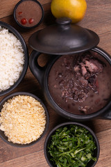 complete feijoada with rice, beans, cabbage, farofa, orange and pepper