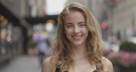 Young blond woman in city face portrait smile happy