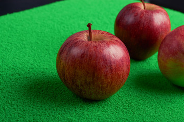 ripe red apples on a green background.selective focus