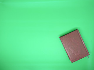 red mushaf al-quran on green background