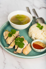 Hainanese chicken with a bowl of soup