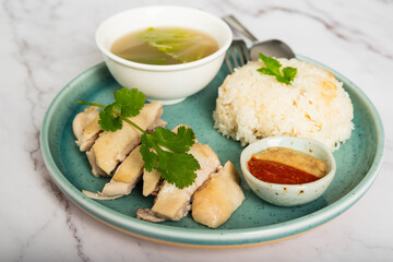 Hainanese chicken with a bowl of soup