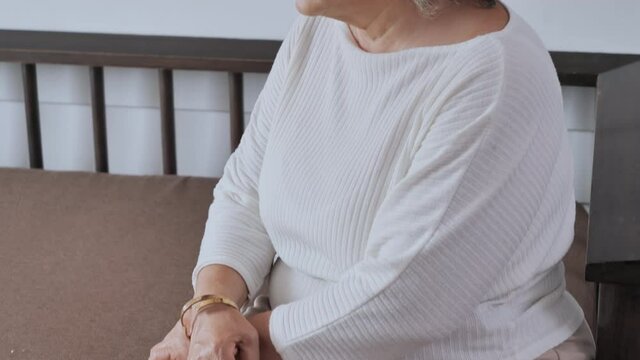 Senior women sitting alone on sofa in living room at home, feeling lonely look in distance thinking pondering.