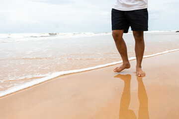 Closeup shot of male feet on smooth sand at the beach