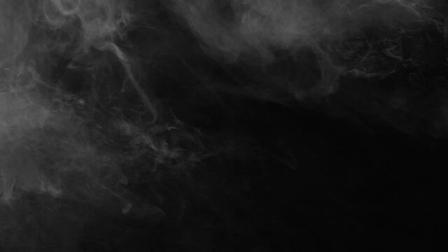 Abstract smoke cloud. White smoke slowly floating through space against black bg. Spooky magic halloween. Atmospheric smoke VFX element. 