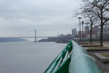 River with Safety Railing and Bridge in the Background