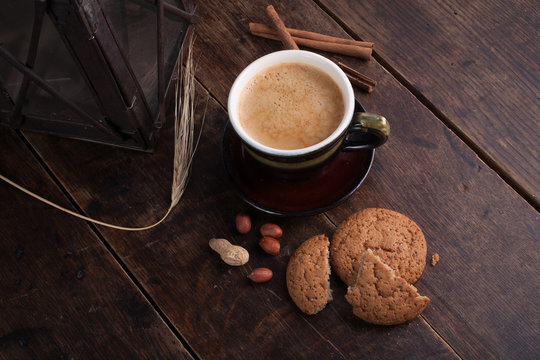 Cup of cofee and cereal cookies on the old wooden table