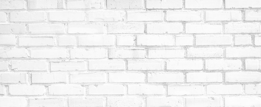 Light white black and gray horizontal brick wall. Old uneven textured surface on a building in the city. Urban background in grayscale. White painted bricks.