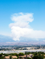 Wildfire smoke emerges from near Banning in the Apple fire of August 2020 in southern California.  The cities of Riverside and Moreno Valley are in the foreground