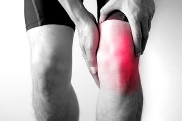 Black and white picture .Knee pain .man stand hand caught at the knee.  health concepts