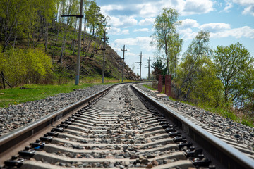 The coast of Lake Baikal on the Circum-Baikal Railway. Circum-Baikal railway tour in Siberia with trees, cliffs and mountains at coast. 
Baikal.
