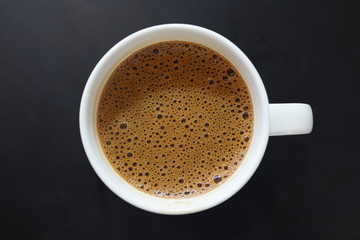 Directly above view a cup of coffee on dark background