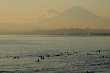 鵠沼海岸の海で波を待つサーファーと富士山