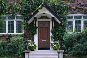 front door of old vine covered house with leaded glass windows