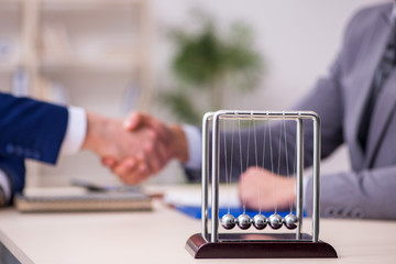 Two businessmen and meditation balls on the table
