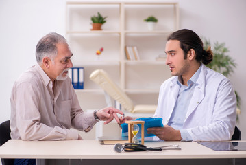 Obraz premium Old male patient visiting young doctor in time management concep