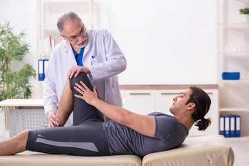 Fototapeta premium Young male patient visiting old doctor traumatologist
