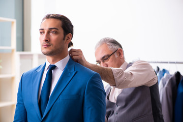 Young businessman visiting old male tailor