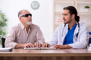 Old blind man visiting young male doctor