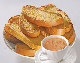 Crunchy Rusk or Toast for healthy life, Traditional biscuit tray with tea, toasts for breakfast and cup of fresh milk & Tea, dry toast bread, crunchy toast, crispy milk rusk, butter roasted bread