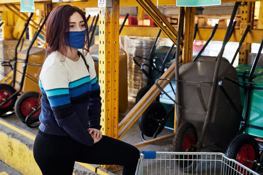 young woman wearing a mask in the middle of a construction materials and tools store