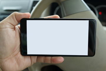 Close up adult hand holding a blank screen smartphone in car