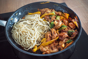 chef cooking noodle with vegetables and chicken