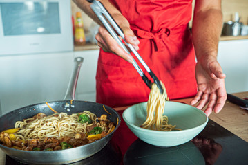 chef cooking noodle with vegetables and chicken