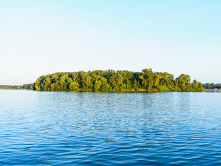 Green island against the background of blue water of Lake Senezh