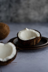 Cracked coconut arranged on textured background.