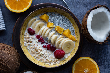 Oatmeal with chia seed, bananas and oranges served in a bowl