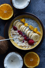 Oatmeal with chia seed, bananas and oranges served in a bowl