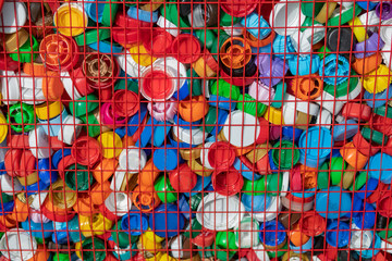 Obraz premium Texture of multi-colored plastic lids in a box of red rods. Recycling of recyclable materials. 