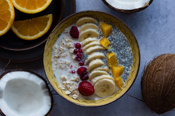 Oatmeal with chia seed, bananas and oranges served in a bowl