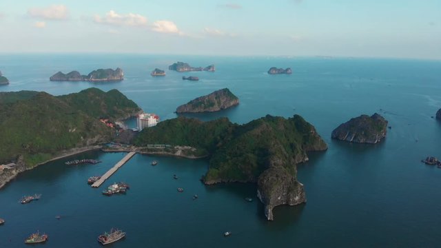 Aerial: flying over Cat Ba island at dusk, Ha Long Bay unique limestone rock peaks in the sea famous tourism destination in Vietnam. Scenic bay of water between headlands.