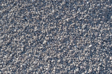A pile consisting of layers of fine gray and white rubble sifting. Grainy gravel background for the...
