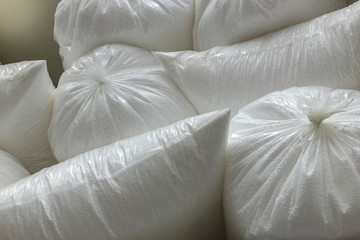 Bags with polystyrene beads at a building materials warehouse in a store. The insulation is in the distribution warehouse.