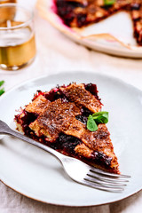 Slice of Delicious Homemade Berries Honeysuckle Pie on beige linen tablecloth. Selective focus