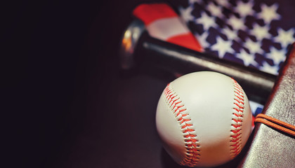 American traditional sports game. Baseball. Concept. Baseball ball and bats on a table with american flag.
