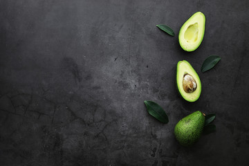 Avocado cooking recipes. Ripe green avocado on a wooden cutting board for serving.