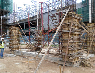 KUALA LUMPUR, MALAYSIA -MARCH 13, 2020: Column timber form work and reinforcement bar at the construction site. Installed by construction workers. The structure supported by temporary wood support.