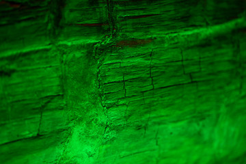 Texture of old cracked tree illuminated by green spotlight