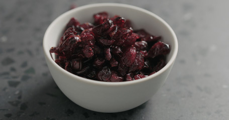 closeup dried cranberry in white bowl on terrazzo countertop