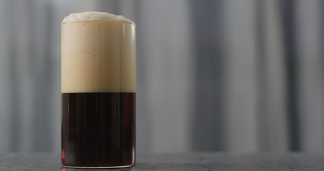 dark beer in glass on concrete countertop