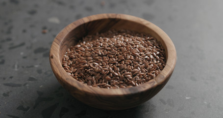 flaxseed in olive bowl on terrazzo countertop with copy space