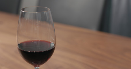 wineglass with red wine on walnut table with copy space
